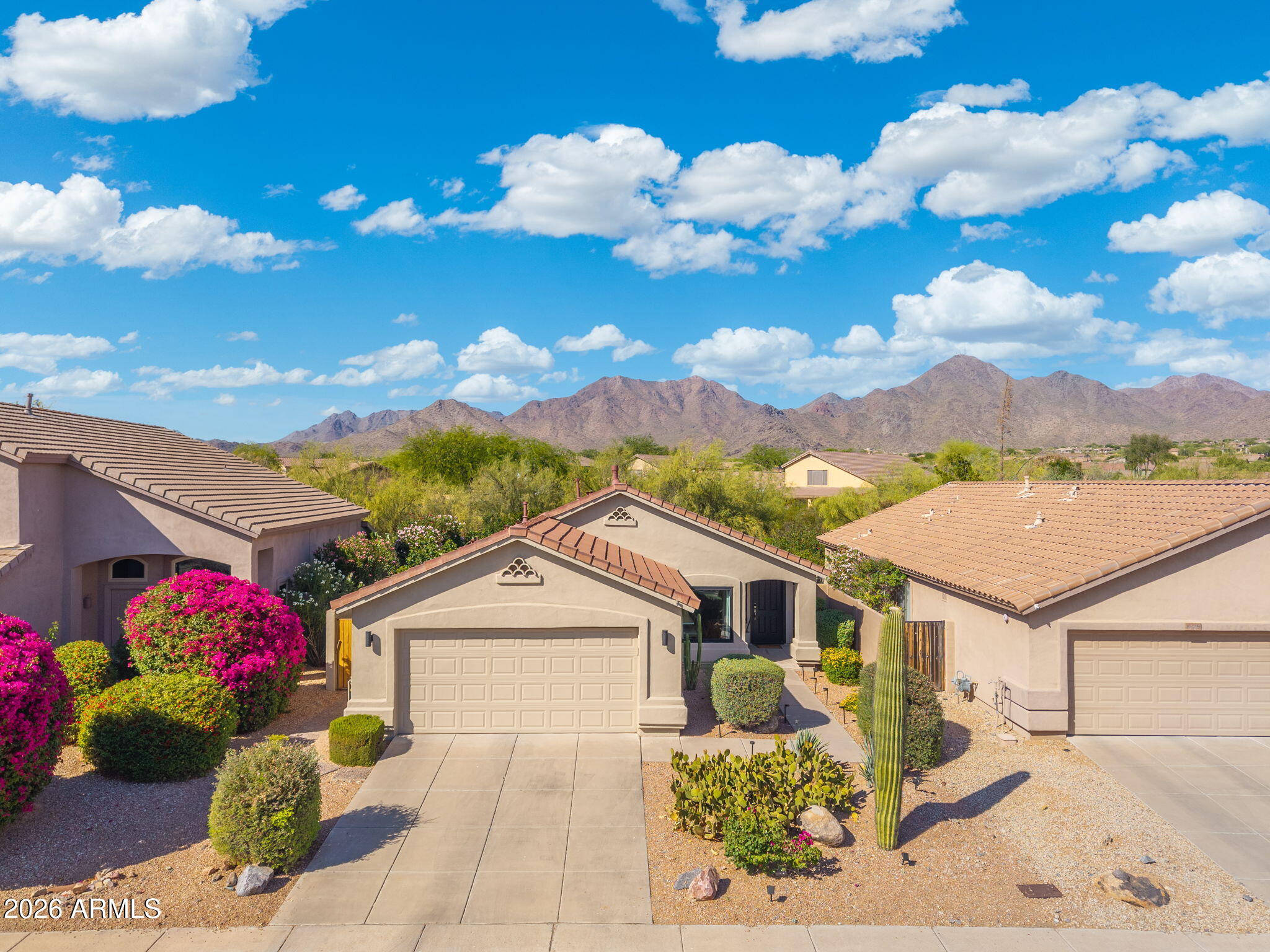 Exterior after, aerial drone photo with McDowell Mountain backdrop and bougainvillea in bloom