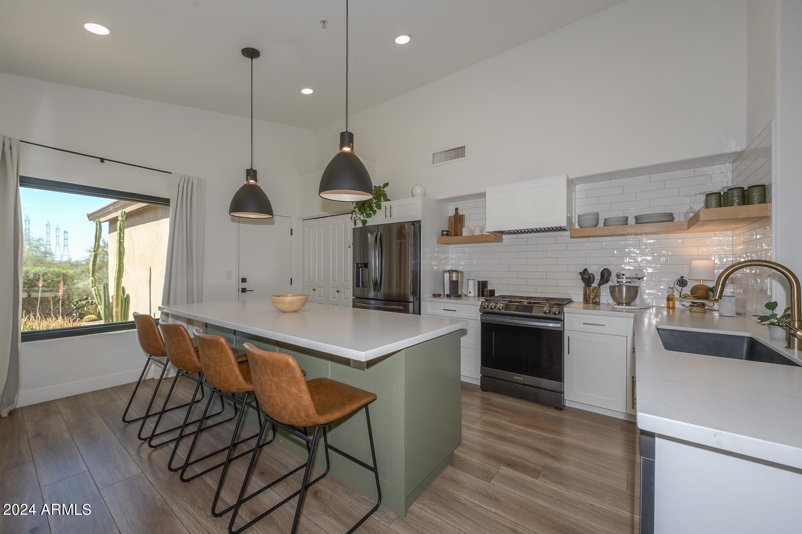 Kitchen before, cluttered island styling, leather barstools, busy composition
